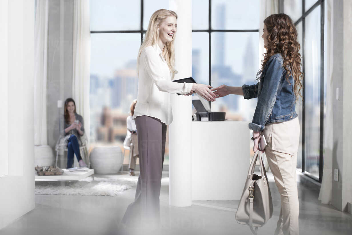 Two women shaking hands in office